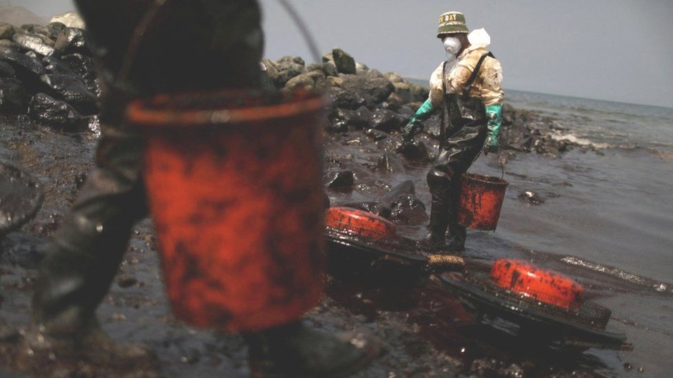 Workers clean up an oil spill