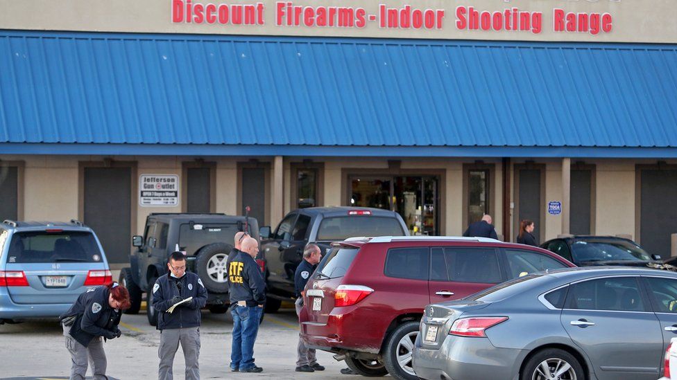 Investigators with the Jefferson Parish Sheriffs Office look at a shell casing in the parking lot of the Jefferson Gun Outlet as investigators work the scene on February 20, 2021 in Metairie, Louisiana.