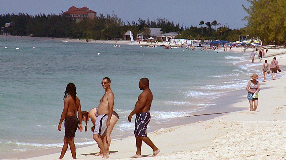 tourists on a beach in Grand Cayman