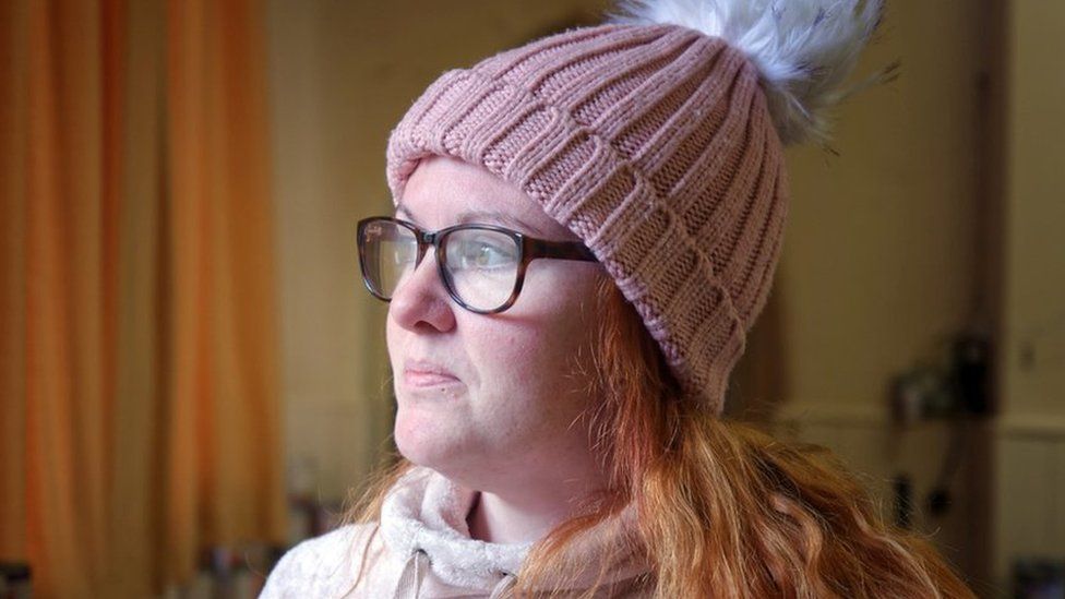 Mrs Tierney shown side on wearing a pink bobble hat