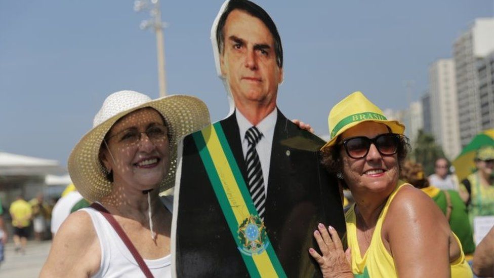 Demonstrators pose next to a cardboard cutout image of Brazil"s President Jair Bolsonaro as they attend a protest against corruption and in favour of the "Car Wash" corruption investigation, in Rio de Janeiro, Brazil April 7, 2019