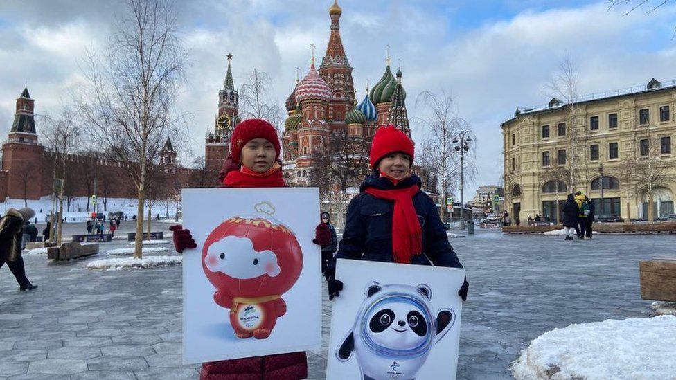 Two children hold pictures of Bing Dwen Dwen and Shuey Rhon Rhon, mascots of the Beijing 2022 Winter Olympic and Paralympic Games on January 16, 2022 in Moscow