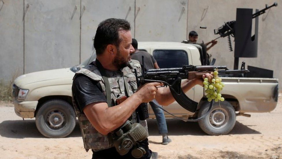 A fighter of Libyan forces allied with the UN -backed government fires a rife at Islamic State fighters during a battle in Sirte (31 July 2016)