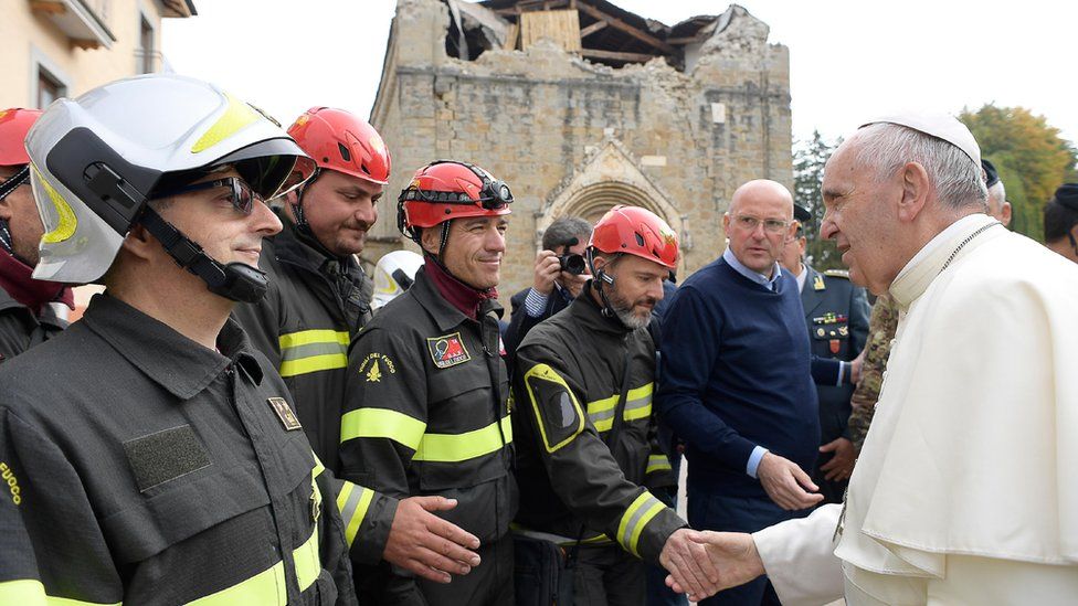 Pope Francis shakes hands with firefighters at the destroyed St Augustine Church in Amatrice, Italy, 4 Tuesday 2016