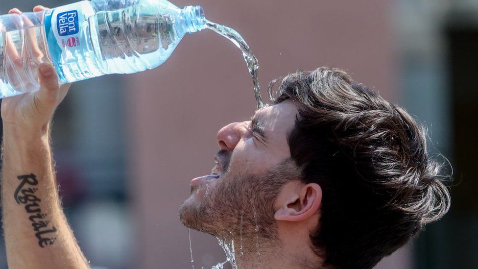 Man pours water over himself in Madrid, 12 July 2022