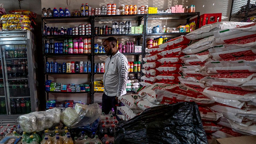 Getachew Desta behind the cage in his shop in Alexandra township, Johannesburg, South Africa