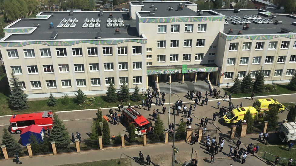Ambulances and police cars gather outside a school in the aftermath of a shooting, in Kazan, Russia, 11 May 2011