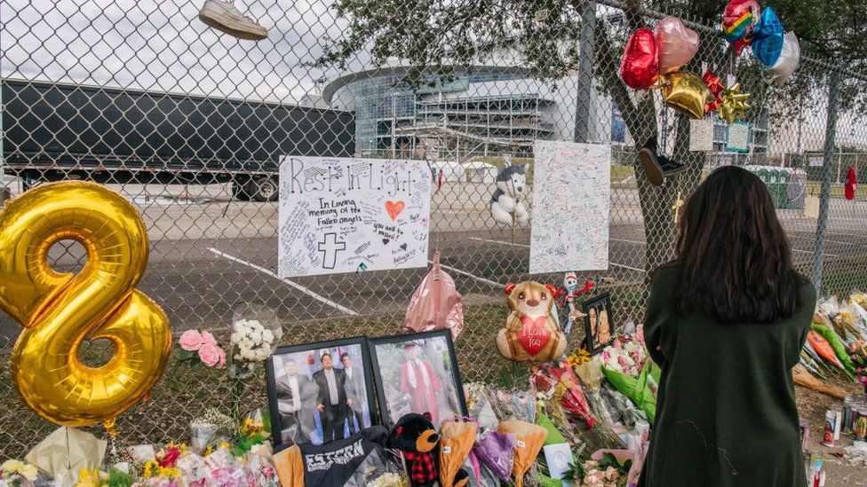 A woman stands at a memorial outside NRG Park, where the Astroworld Festival was held.