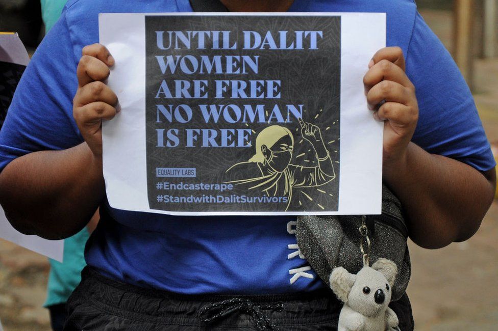 A protester holds a placard during a demonstration against caste-based sexual violence.