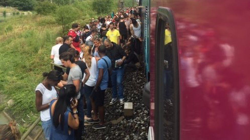 Passengers wait outside train after crash in Herault (17 Aug)