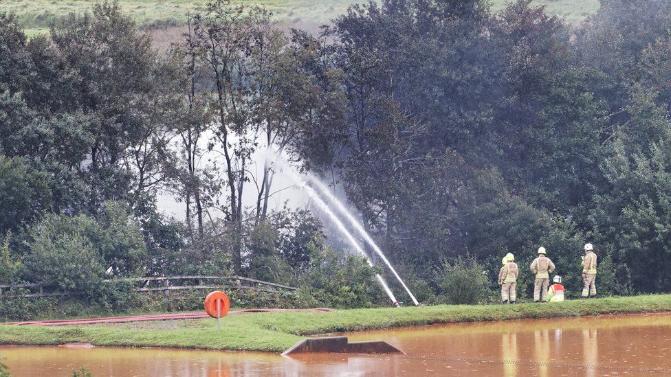 Firefighters pump water on the fire