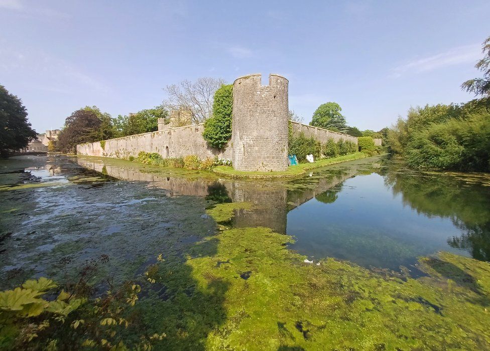 The moat surrounding The Bishop's Palace and gardens in Wells in Somerset