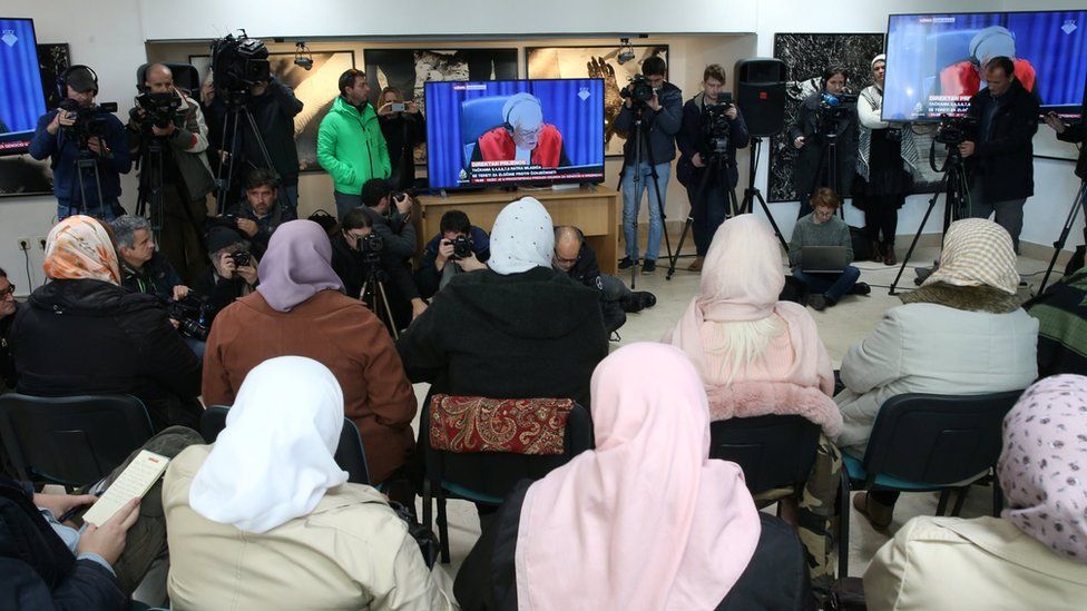 Victims and their family members watch a television broadcast of the court proceedings of former Bosnian Serb general Ratko Mladic in the Memorial centre Potocari near Srebrenica,