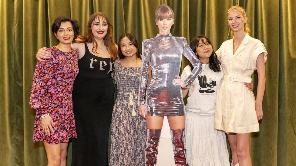 Fans pose with a cut out of Taylor Swift