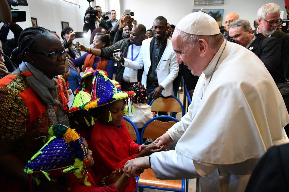 Pope Francis greets children during his visit to a centre run by the Catholic humanitarian organisation Caritas, which hosts migrants, in the Moroccan capital Rabat, 30 March