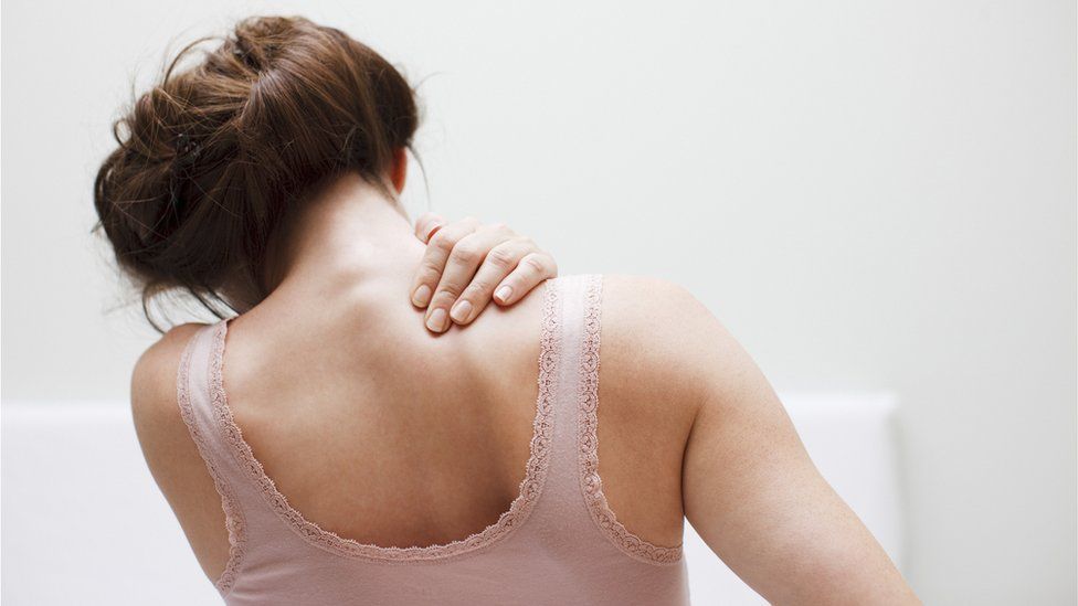 Woman holding shoulder in pain
