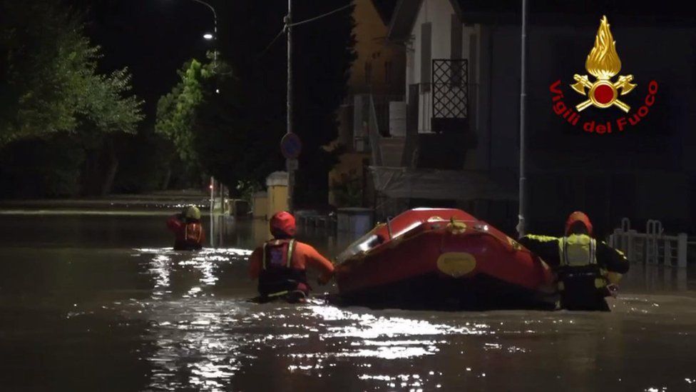 Image shows dinghy in flooded street