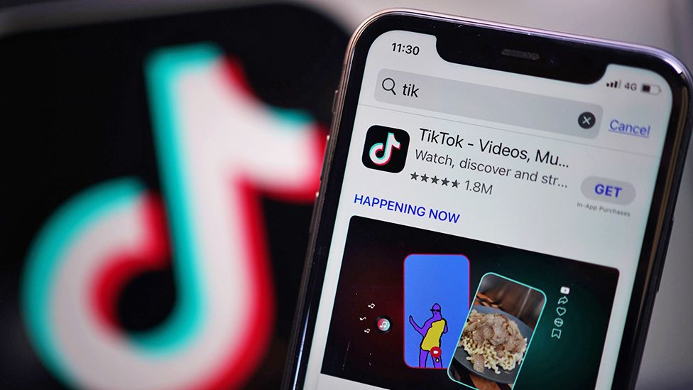 TikTok on phone with logo in background