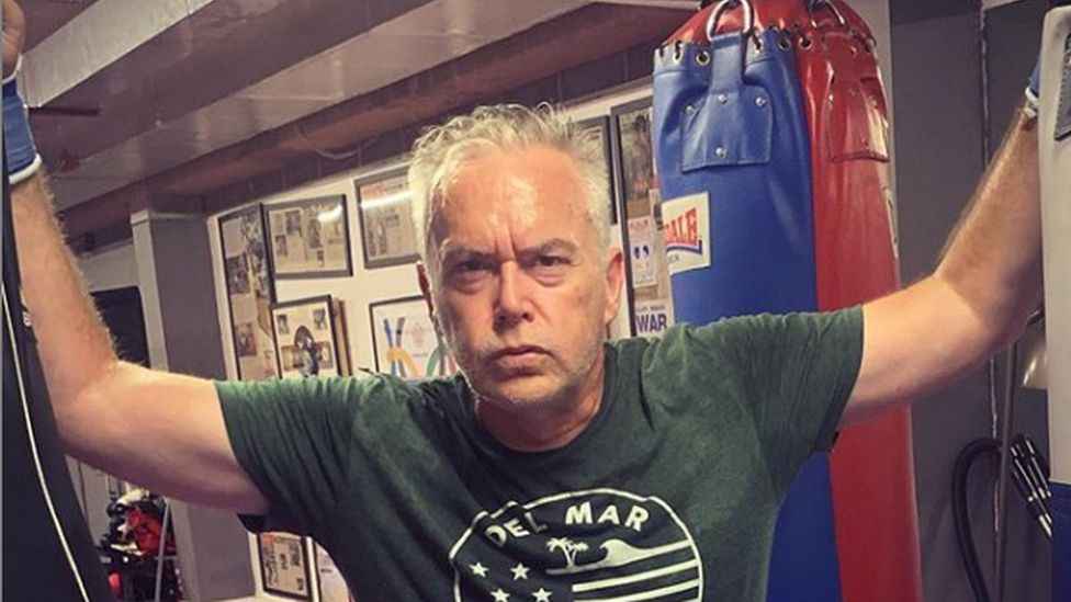 Huw Edwards in front of a boxing bag