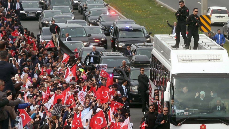 Turkish President Tayyip Erdogan waves to supporters from a parade bus in Ankara, 17 April