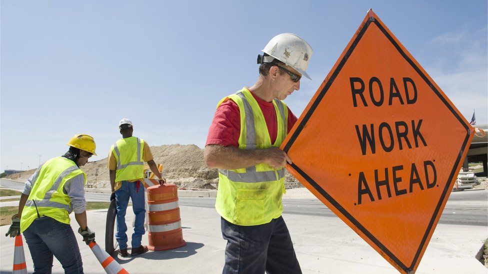 Roadworkers moving signs