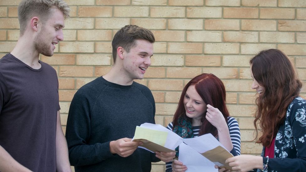 Four students look at each other as they open their results