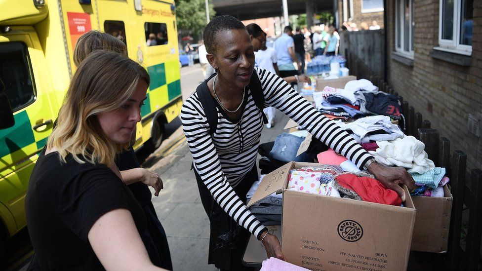 Women carrying donated clothes on 16 June