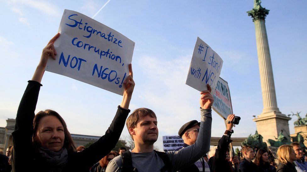 People hold placards during a protest against a new law that would undermine Central European University in Budapest on 15 April