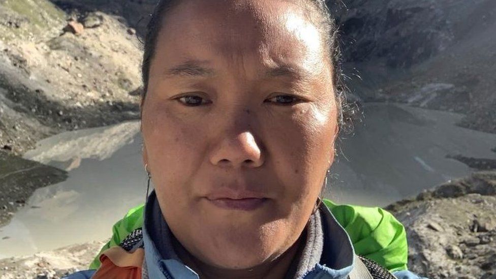 Lhakpa Sherpa's face close-up with a mountain valley behind her