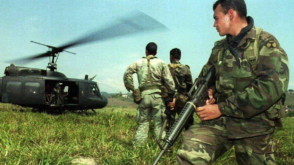 A member of a special forces Colombian army unit watches as an army helicopter takes off from a makeshift helicopter landing strip at a small village some 80km south of Medellin 25 February 1993