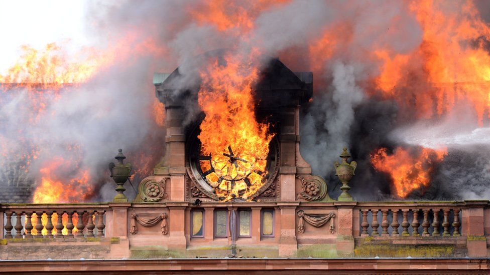 Flames destroy the clock at the top of the Bank Buildings