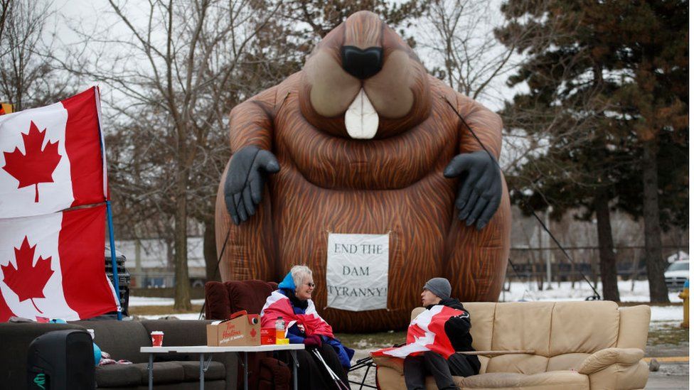 Protestors and supporters sit at a blockade at the foot of the Ambassador Bridge