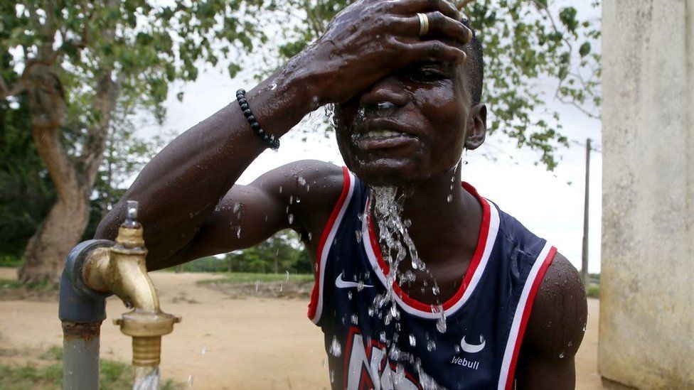 A man washes his face with tap water