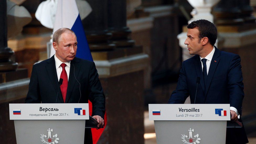 French President Emmanuel Macron (R) delivers a joint press conference with Russian President Vladimir Putin following their meeting at the Versailles Palace