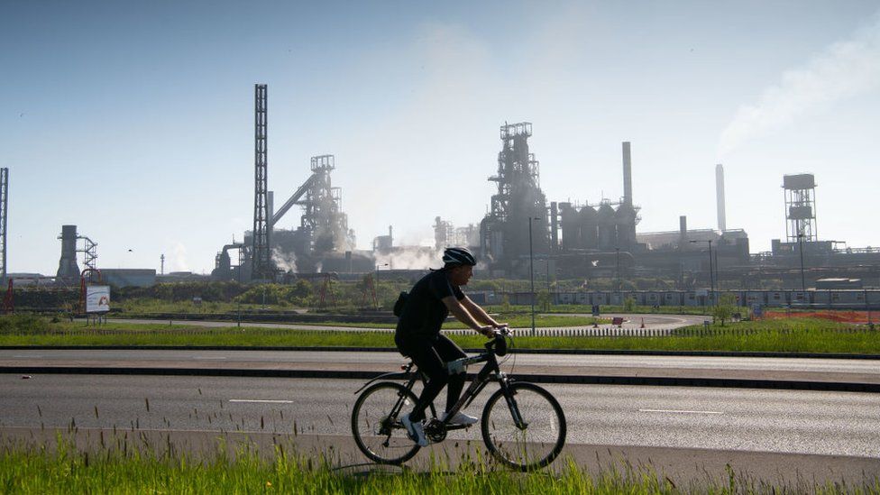 A man riding his bike past Port Talbot's steel works