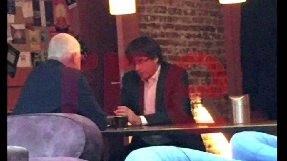 Screengrab with watermark shows Carles Puigdemont in a Belgian cafe on the day he is due in Madrid