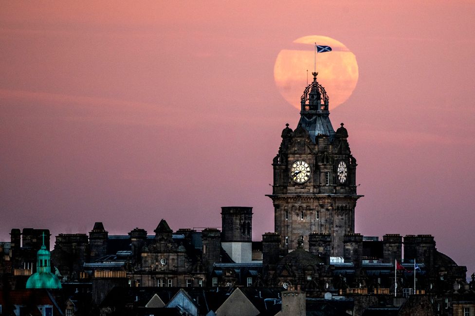The moon sets behind the Balmoral Hotel Clock in Edinburgh