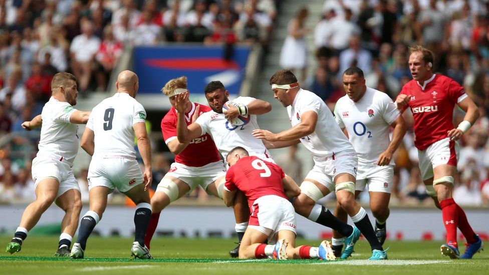 England's Lewis Ludlam (centre) is tackled by Wales's Gareth Davies during England's match against Wales