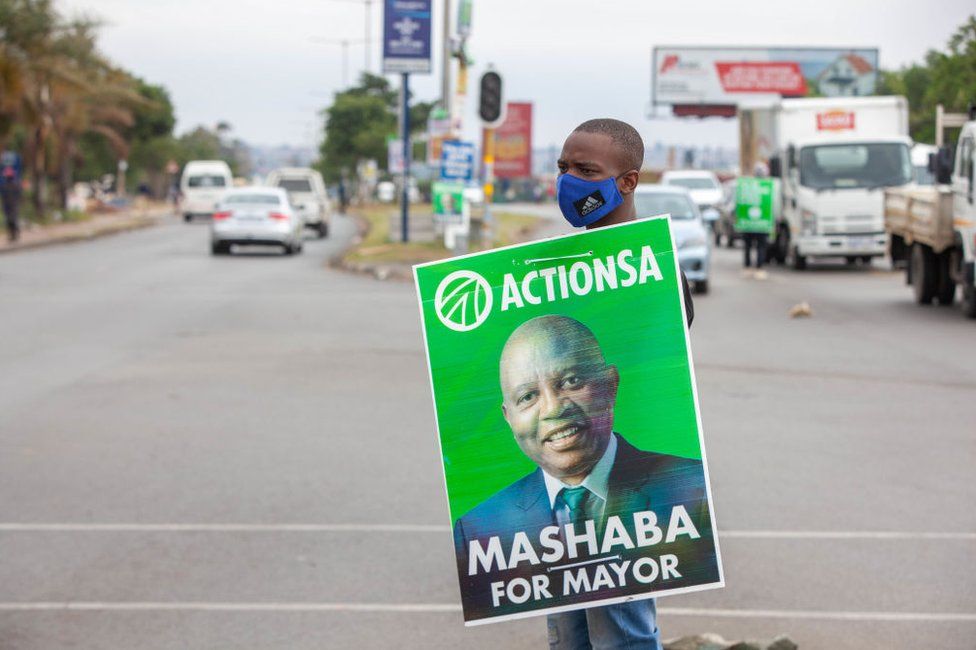 An ActionSA campaigner holds a banner that reads "Mashaba for mayor" in Soweto, South Africa, on 27 October.