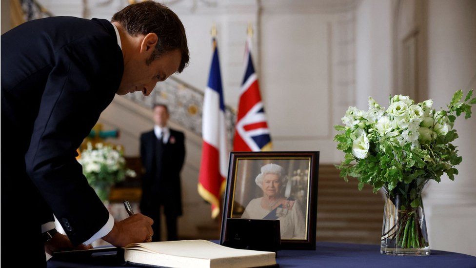 French President Emmanuel Macron signs a condolence book in Paris
