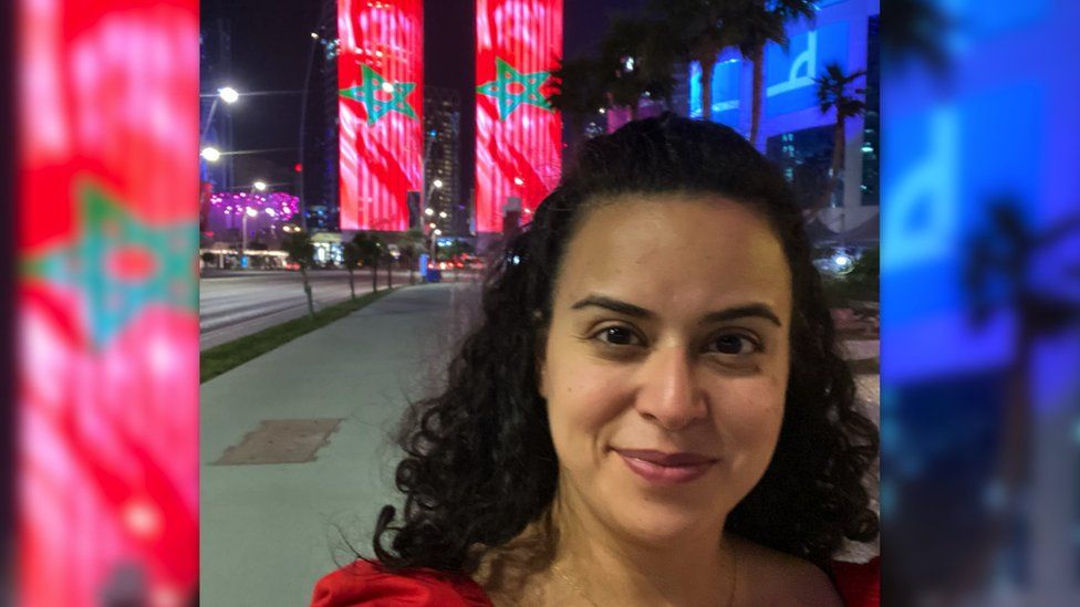 BBC journalist Lina Shaikhouni in front of two towers with the Moroccan flag projected on them in Doha