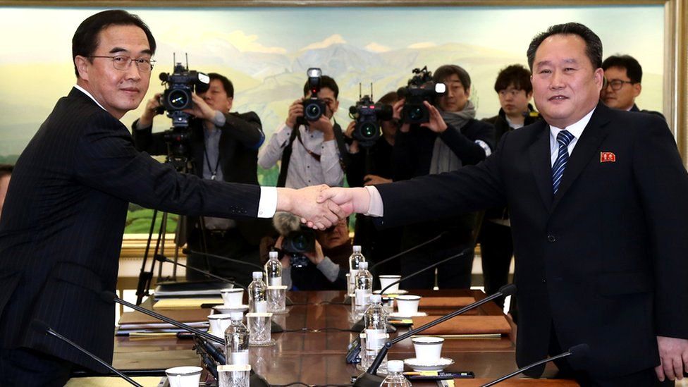 South Korean Unification Minister and chief delegate Cho Myoung-gyon (L) shakes hands with his North Korean counterpart Ri Son-gwon