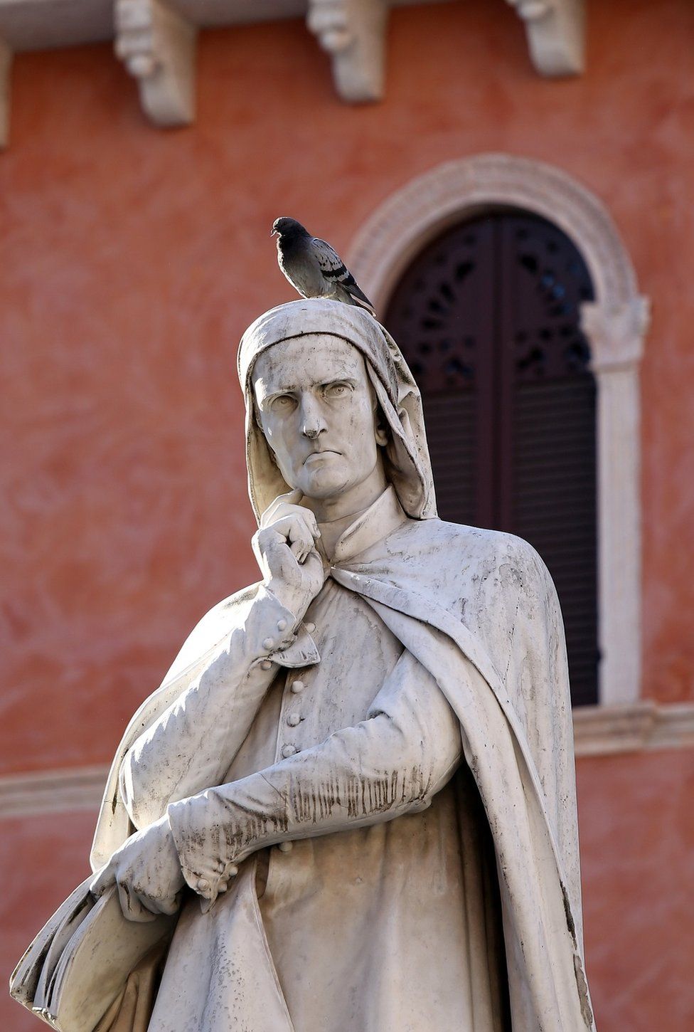 A pigeon on top of a statue