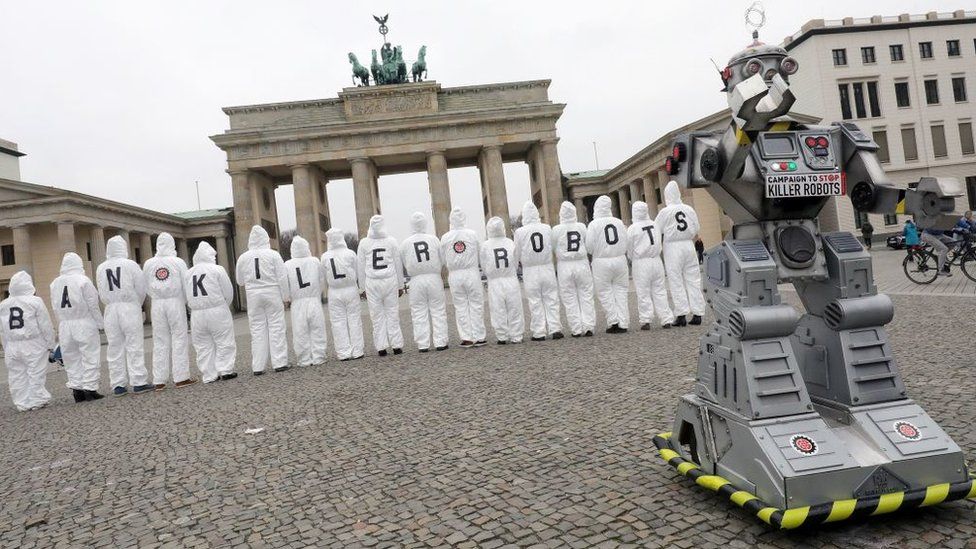 Ban Killer Robots protest with robot in front of campaigners at Brandenburg Gate in Berlin