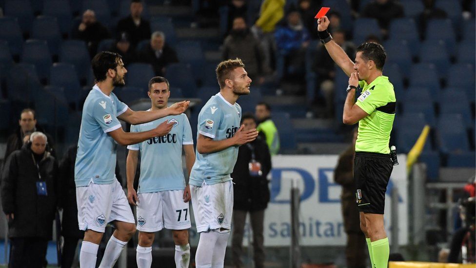 Piero Giacomelli presents a red card to Lazio"s Italian midfielder Ciro Immobile