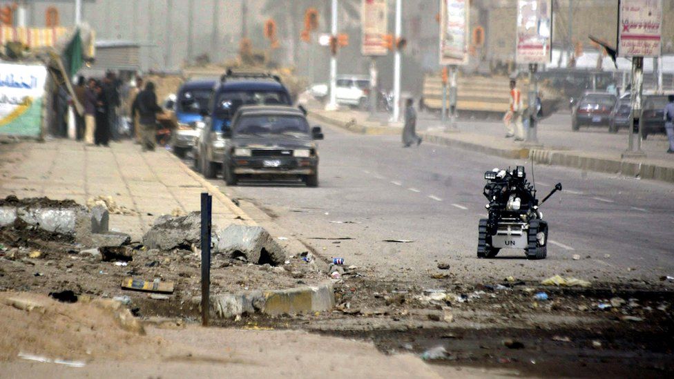 British troops use a bomb defuser robot to inspect the site where a roadside bomb exploded in Basra