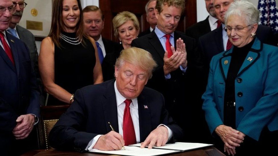 US President Donald Trump signs an executive order on healthcare at the White House.