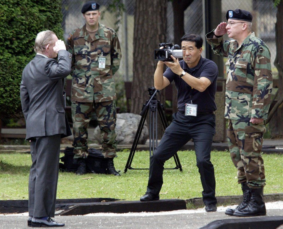 Charles Jenkins salutes Lieutenant Colonel Paul Nigara, as he is return to US military control at Camp Zama in Japan, on 11 September 2004.