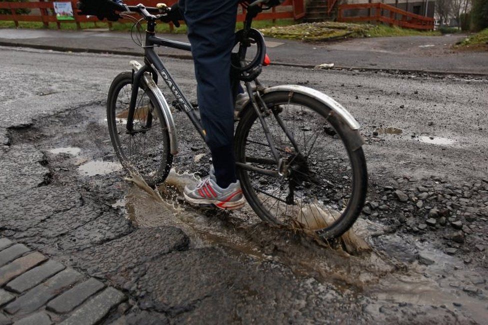 Cyclist going through pothole