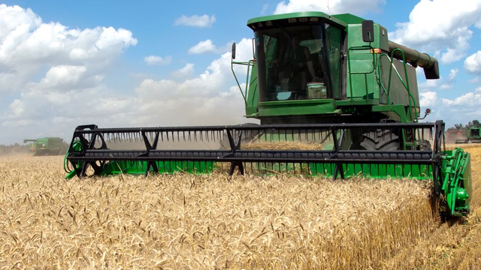 Stock image of a combine harvester working on a wheat field